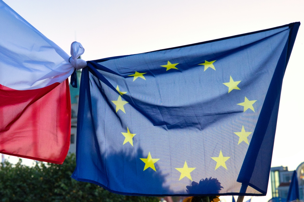 Eine Flagge Polens und eine EU-Flagge miteinander verknotet Polnische und EU-Flagge